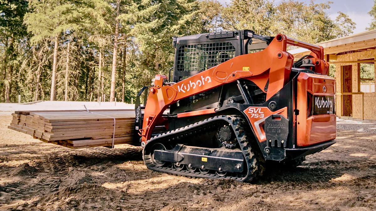 A skid steer bobcat from Dynamic Earth Solutions performing earthworks for building preparations.