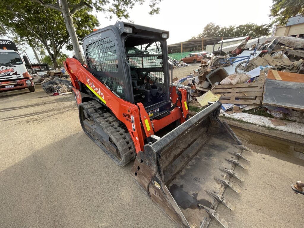 Skid steer loader operated by Dynamic Earth Solutions efficiently clearing household waste.