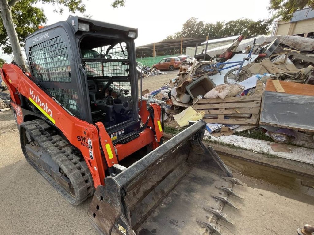 Dynamic Earth Solutions Kubota skid steer loading a pile of demolition and clean-up debris on a south-east Queensland job